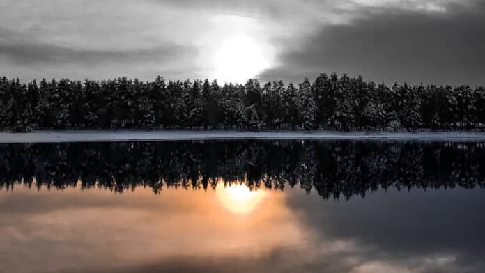 Sunset in winter landscape reflecting in the sea.